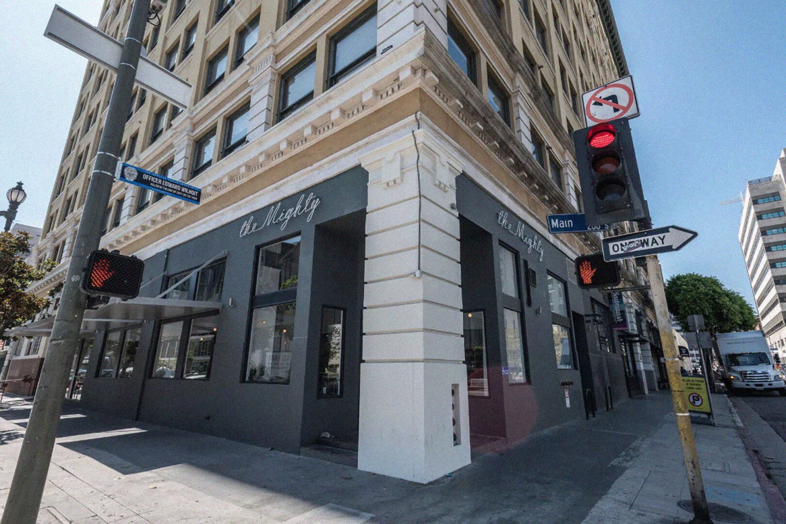Corner view of a city street with a building marked "the whitley," showing traffic lights and street signs at the intersection of main and 9th.